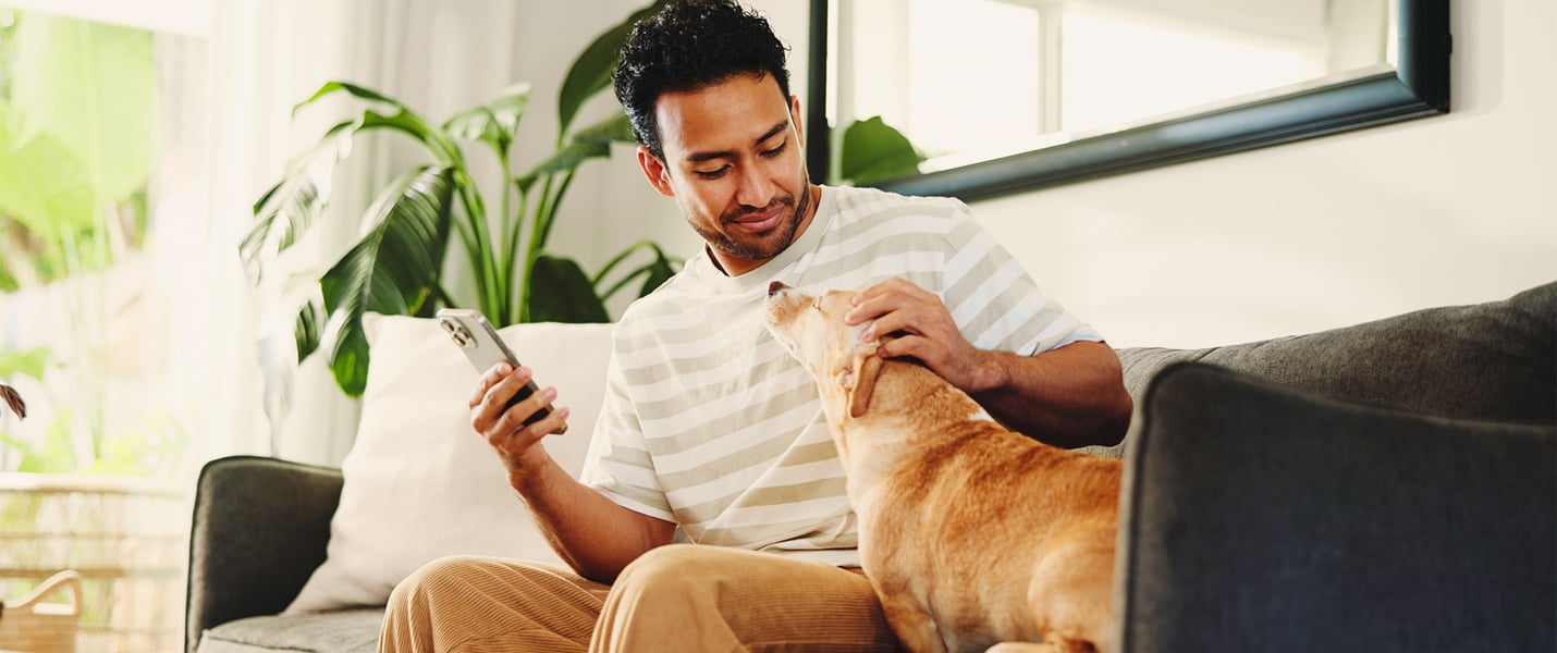 A man sitting on a sofa with his dog.