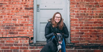 A woman sitting on a step with her dog
