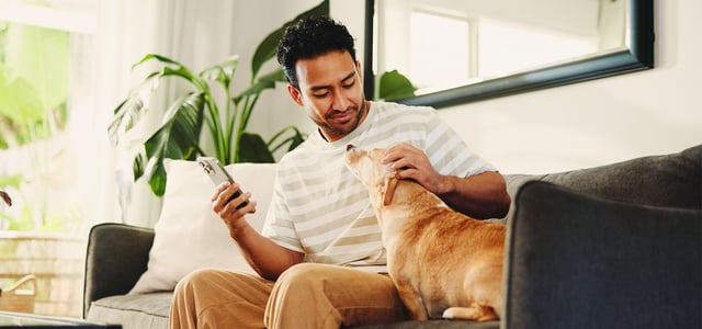 A man sitting on a sofa with his dog.