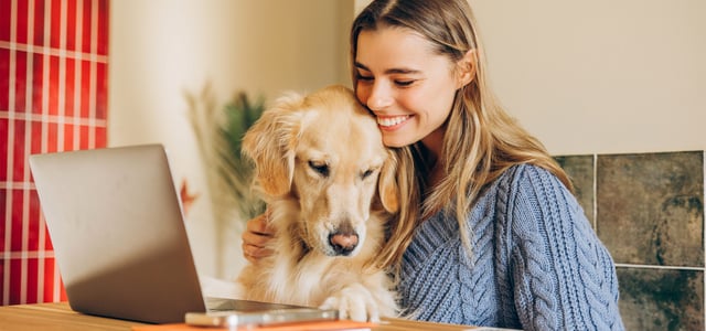 A woman smiling with her golden retriever.