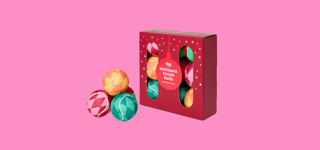 A range of festive tennis balls against a pink background.