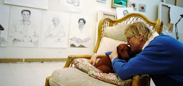 David Hockney kissing his dachshund.