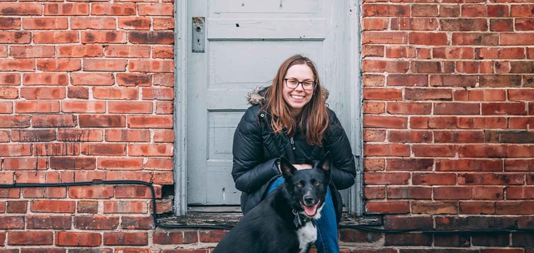 A woman sitting on a step with her dog