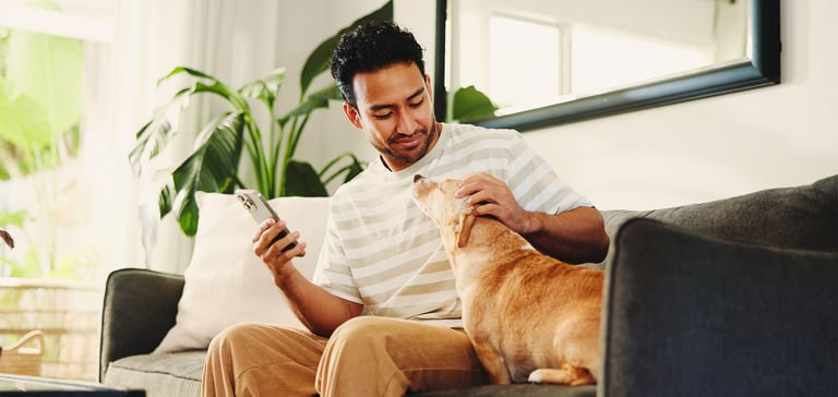 A man sitting on a sofa with his dog.