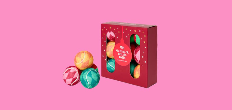 A range of festive tennis balls against a pink background.