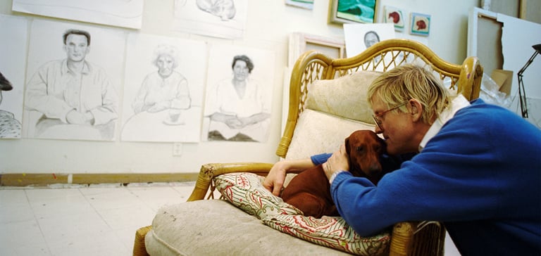 David Hockney kissing his dachshund.