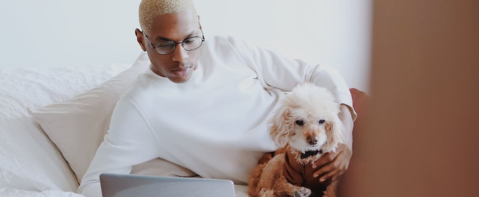 A man with his dog at a laptop
