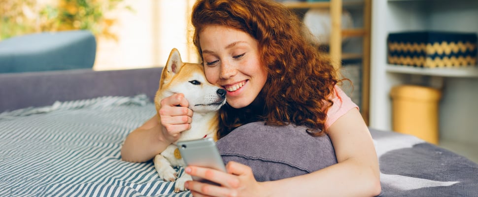 A smiling woman sat with her Shiba Inu.