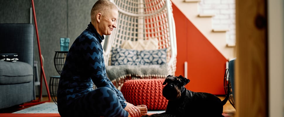 A dog owner sharing a yoga mat with their dog.
